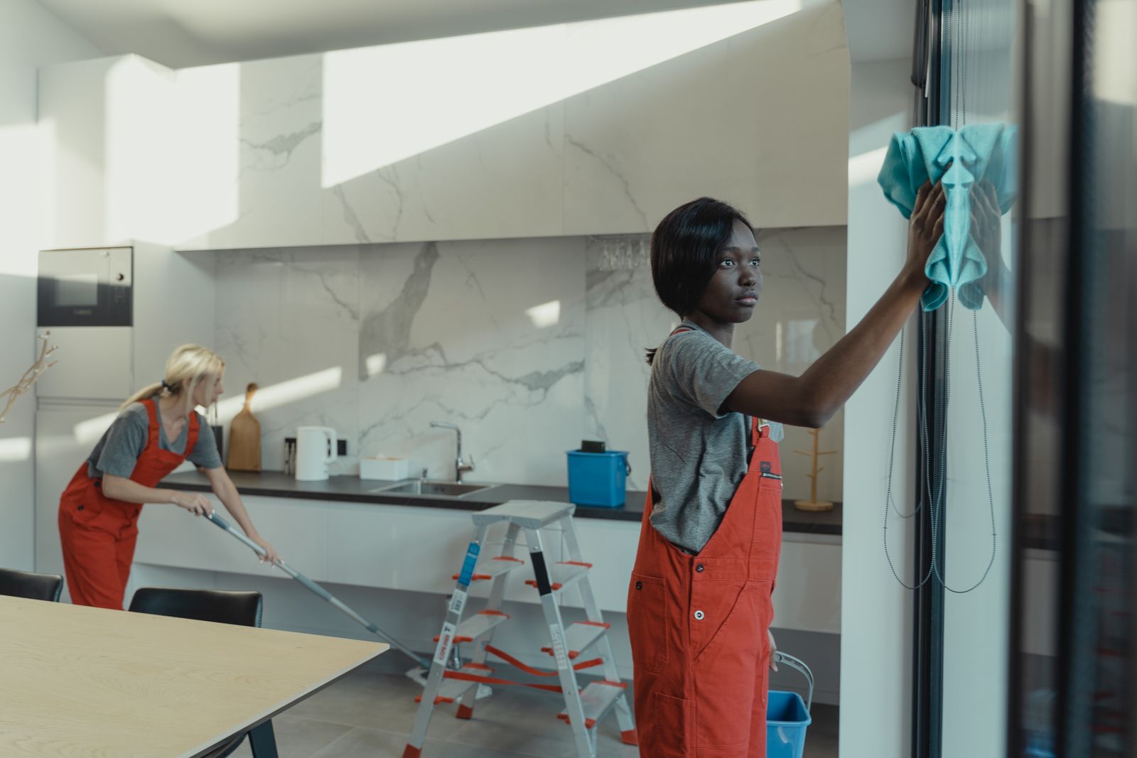Two Crisp & Co. technicians cleaning a modern kitchen